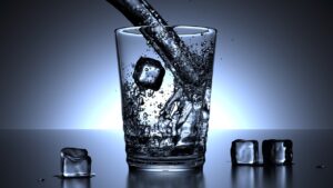 A foto retrata um copo de agua com gelo.