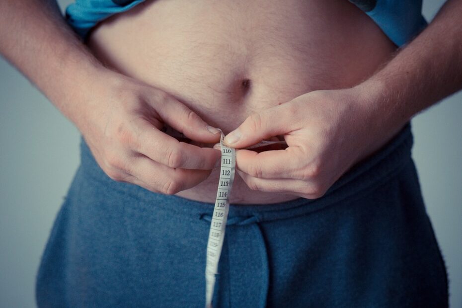 Emagrecer em 1 semana: Foto de uma pessoa utilizando uma fita métrica para medir a barriga.