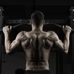 Calistenia e Hipertrofia: Como Ganhar Massa Muscular com Saúde Homem de costas fazendo barra fixa. Músculos das costas, braços e ombros definidos e aparentes, demonstrando o resultado da hipertrofia alcançada com a calistenia.