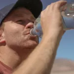 homem tomando garrafa d'agua desidratação no calor